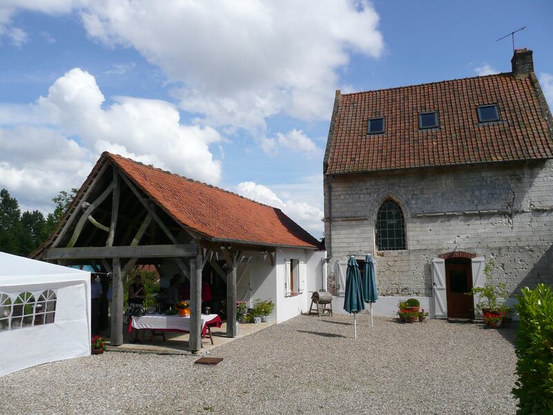 The gravel courtyard, with the timber-framed covered terrace on the left and the stone chapel on the right