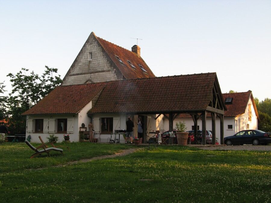 The long kitchen wing and covered terrace in low evening light, the chapel roof behind