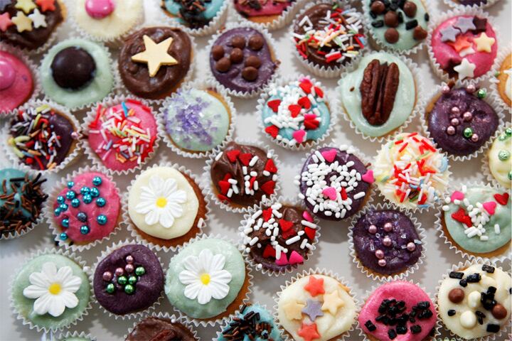 Rows of brightly iced cupcakes for a wedding
