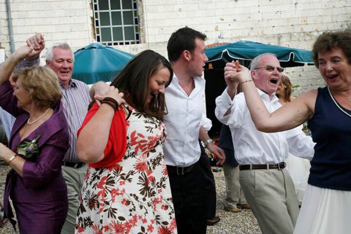 Wedding guests dancing in the courtyard under the parasols